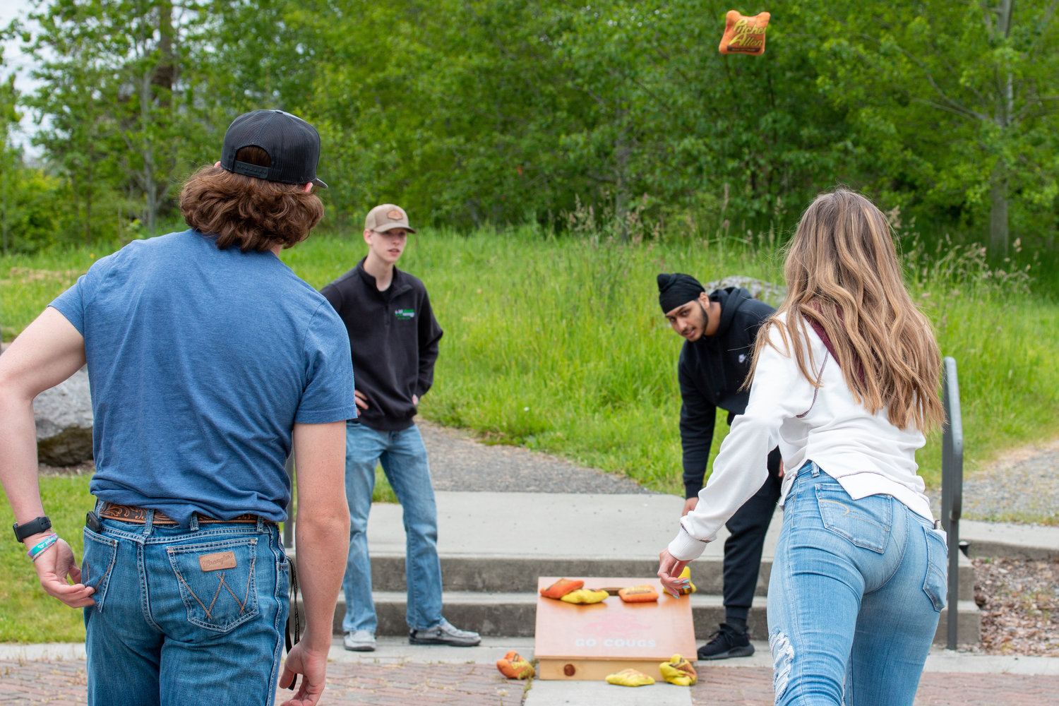 People toss bean bags while playing cornhole at the Centralia College SpringFest Tuesday afternoon.